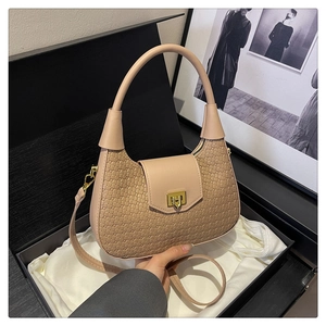 Detail of beige woven hobo bag with gold metal lock in an elegant gift box presentation