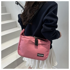 Dettaglio borsa a tracolla in nylon rosa con etichetta moda su sfondo neutro