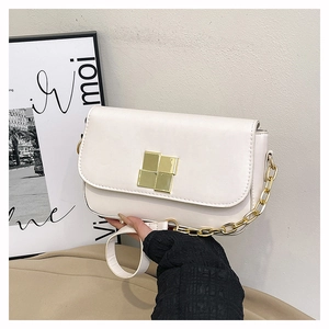 Detail of cream white leather shoulder bag featuring a square gold metal lock and chain