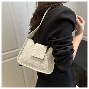 Détail de la texture tressée blanche et du rabat de ce sac à bandoulière chic pour femme