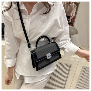 Dettaglio della borsa vintage con trama grigia e finiture in pelle nera elegante