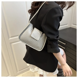 Détail d'un sac à bandoulière argenté à texture tressée avec un fini lustré métallique