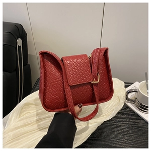 Détail du sac à bandoulière en cuir rouge avec motif tressé et boucle en métal doré