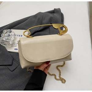 Detail of cream PU leather handbag with unique gold paperclip handle and chain strap