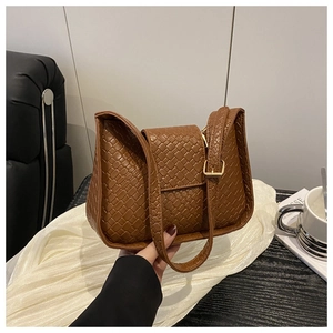 Gros plan détaillé du sac à bandoulière en cuir tressé marron avec sangle réglable