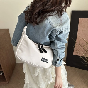 Borsa a tracolla a mezzaluna in nylon bianco con cerniere nere e label fashion