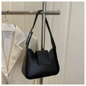 Vue détaillée du sac porté épaule tissé noir avec texture fine et boucle dorée