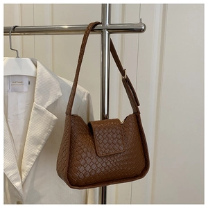 Détail d'un sac hobo en cuir tressé marron foncé avec texture damier classique