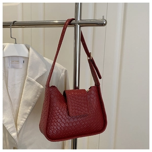 Détail du sac bandoulière en cuir tressé rouge montrant la texture et le rabat