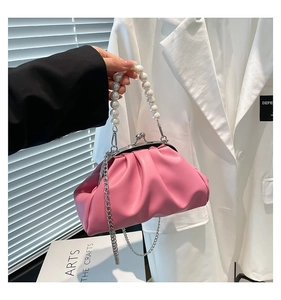 Detailed macro of pink pleated cloud bag with pearl handle and metal chain strap