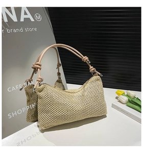 Close-up of woven straw tote bag featuring pink leather straps and knot details