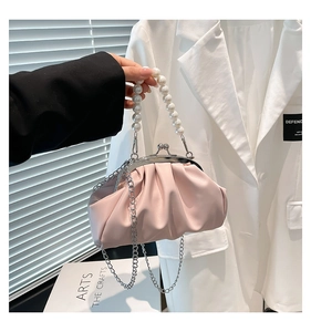 Detailed close-up of pink pleated cloud bag with elegant pearl handle and metal clasp