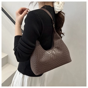 Close-up of a dark brown woven hobo bag showing retro texture on a female model