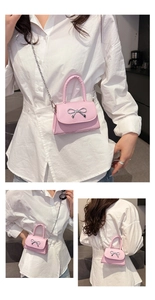 Gros plan sur le mini sac bandoulière rose avec nœud argenté et chaîne en métal