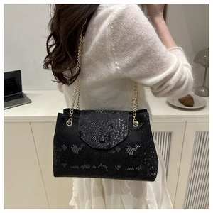 Detail of grey snakeskin texture shoulder bag with elegant gold chain straps