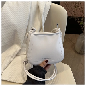 Close-up of white PU leather crossbody bag featuring knot strap detail and logo