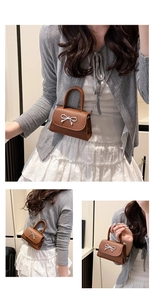 Détail du mini sac à bandoulière marron avec nœud argenté et finitions de la chaîne