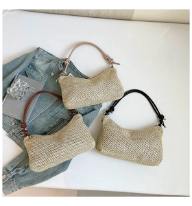 Detail of woven straw tote bags with colorful top handles and intricate knot accents