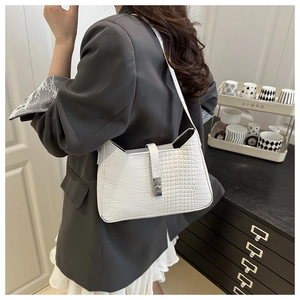 Close-up of white crescent shoulder bag with crocodile pattern and silver metal buckle