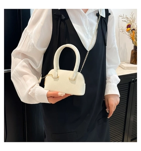 Chic cream white shell bag with lychee texture and gold chain strap on a model