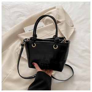 Detail of black glossy leather bucket bag with embossed MEIGE SNUP GOOD lettering
