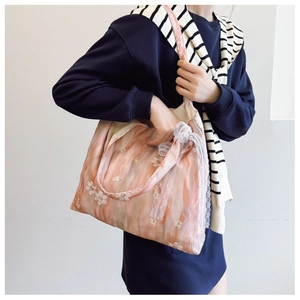 Detail of floral canvas tote bag featuring white flower embroidery and large lace bow