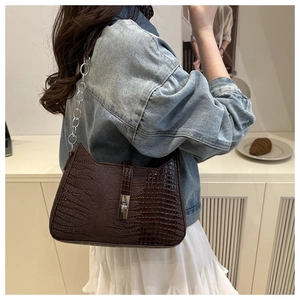 Detail shot of vintage dark brown crocodile embossed shoulder bag with silver chain strap