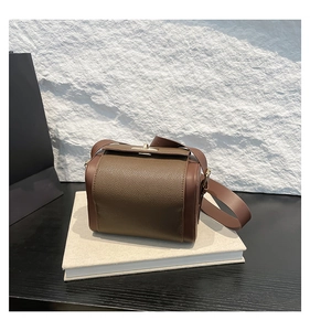 Détail du sac à main en cuir marron foncé avec texture litchi et boucle en métal