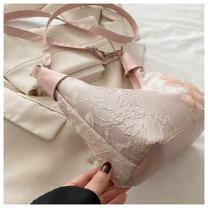 Détails de broderie en dentelle 3D et strass sur un sac à bandoulière rose poudré