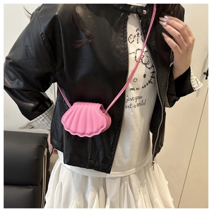 Detail of pink shell-shaped crossbody bag with pleated leather texture and slim strap