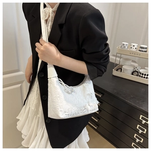 Détail du sac hobo en dentelle blanche avec fleurs 3D et breloques en perles