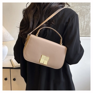 Détail de l'arrière d'un sac carré minimaliste en cuir marron clair dans un décor intérieur