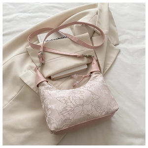 Texture détaillée du sac brodé en jacquard rose avec des motifs floraux sur une veste