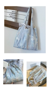 Detail of light blue floral tote bag featuring lace bow and delicate flower embroidery