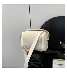 Détails d'un sac bandoulière blanc en cuir grainé avec sa fine bandoulière réglable