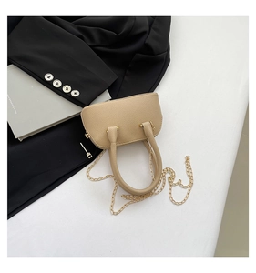 Detail of lychee pattern leather shell bag with golden chain and zip closure