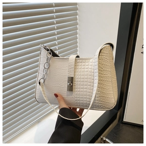 Close-up of white crocodile pattern shoulder bag with silver chain and twist lock
