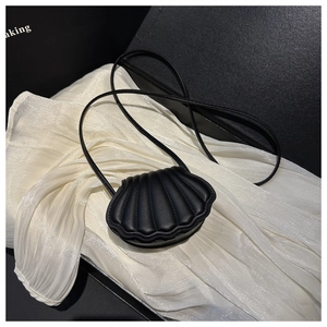 Detail of a black seashell crossbody bag featuring vertical stitching on premium silk fabric