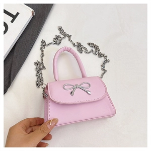 Détail du sac bandoulière rose avec nœud argenté et bandoulière en chaîne élégante