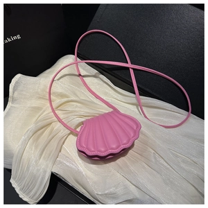 Close-up of pink shell-shaped crossbody bag with elegant curved quilted texture