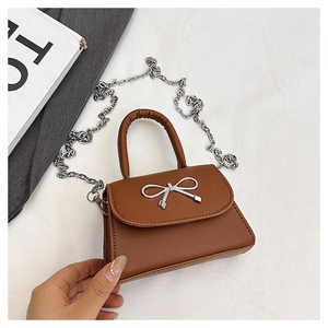 Détail d'un sac à main en cuir marron avec boucle nœud argentée et élégante chaîne en métal