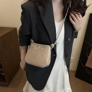 Minimalist beige leather crossbody square bag with knotted strap and textured finish