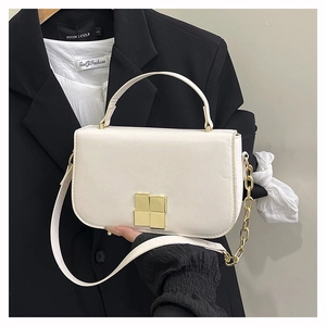 Détail d'un sac à bandoulière crème minimaliste avec un fermoir en métal doré classique