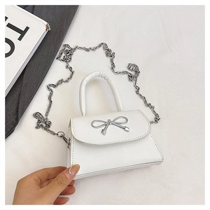 Détail du mini sac blanc avec nœud argenté et texture en cuir PU finement grainé