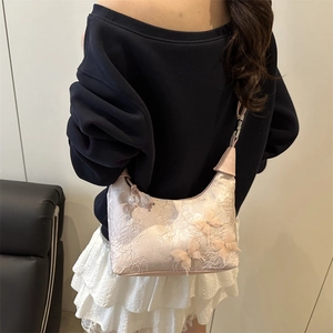 Sac à bandoulière en dentelle rose avec papillons 3D porté par un mannequin stylé
