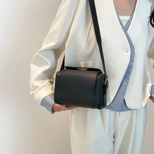 Sac bandoulière minimaliste en cuir noir texturé avec boucle dorée pour femme