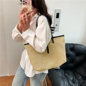 Large straw woven tote bag with black leather straps for summer beach vacations
