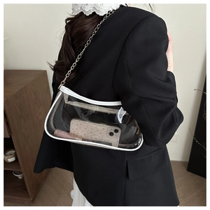 Detail of clear PVC crescent shoulder bag with white leather trim and gold chain strap