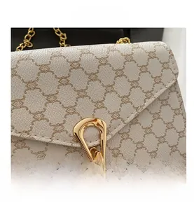 Vue détaillée du sac à rabat monogramme élégant avec chaîne dorée et fermoir en métal doré