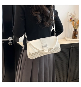 Detail of crossbody bag featuring silver H-buckle and brown monogram pattern leather